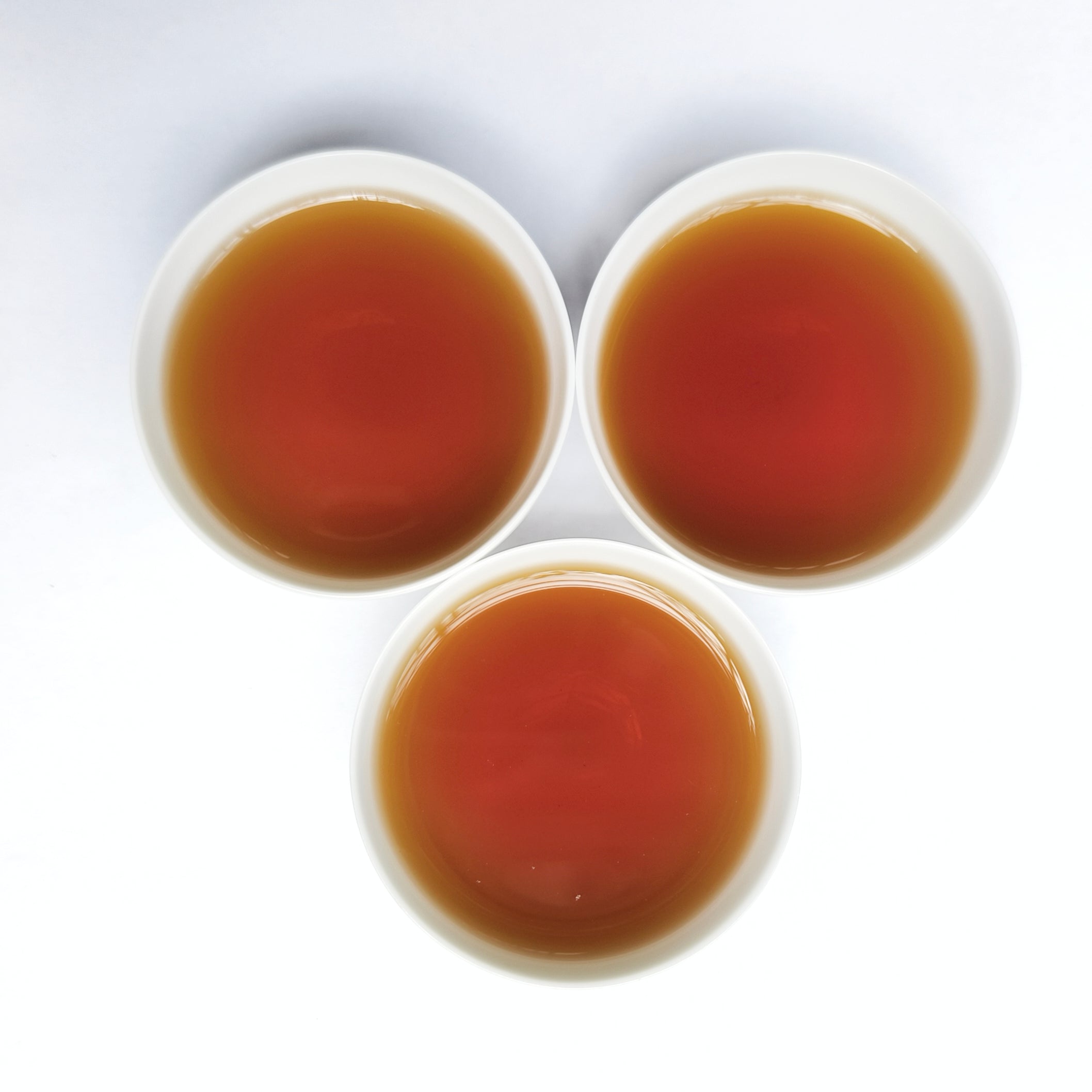 Lao Cha Tou Ripe Shu Puerh Tea being served in white Chinese gongfu tea cups