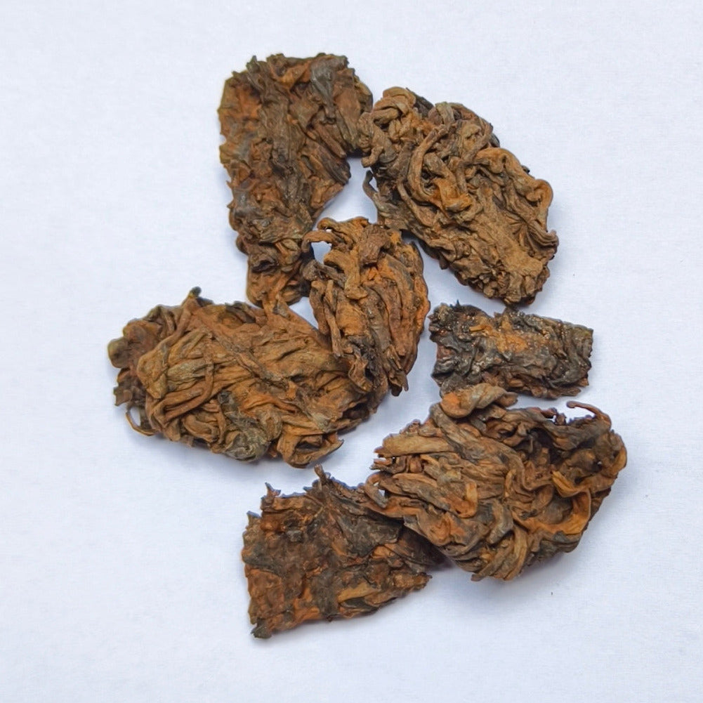 Lao Cha Tou Shu Puerh pieces on a white background. Excellent value aged ripe puerh tea.