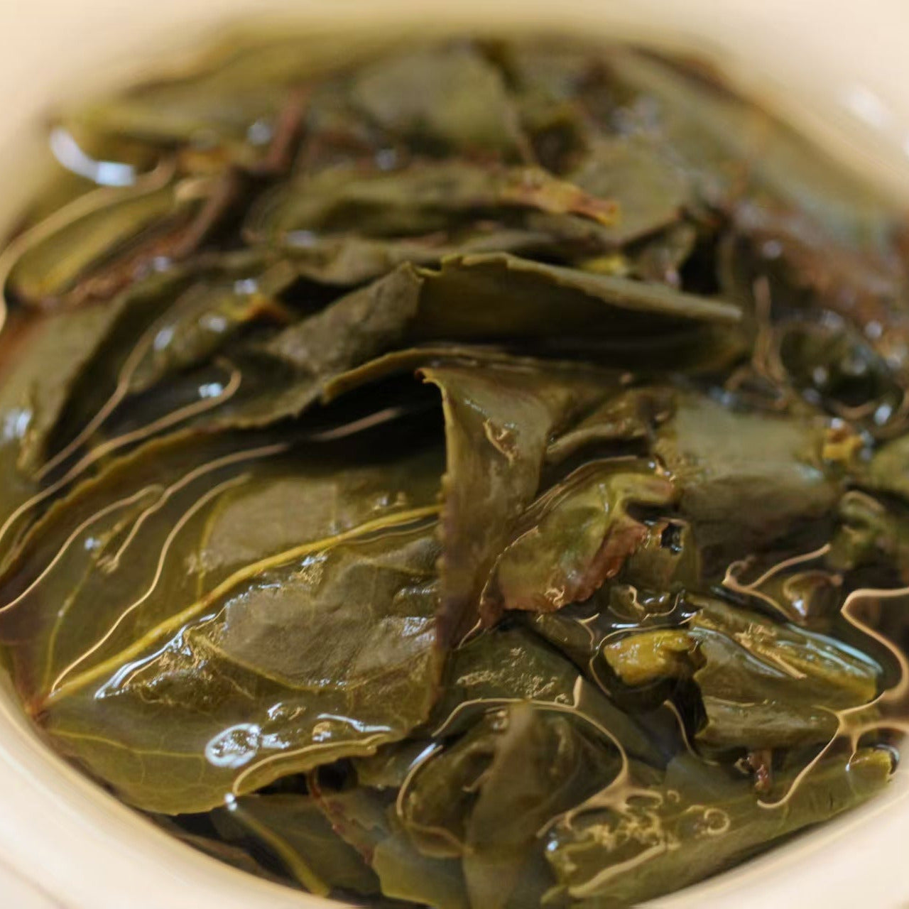 Yeyun Laocong Tieguanyin Oolong Tea being prepared in a white, Dehua gaiwan. Abandoned tea garden Old Bush Tie Guan Yin tea from Anxi, Fujian.