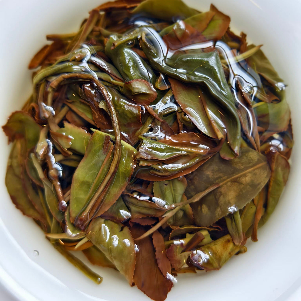 Youyun Tieguanyin Oolong Tea being prepared in a white gaiwan.