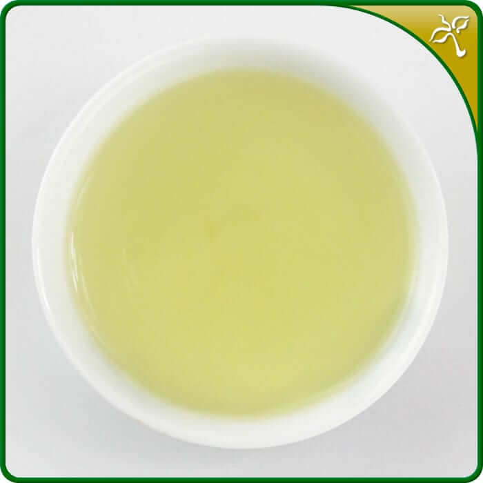 Premium Guanyin Wang tea liquor in a white ceramic, Chinese tea cup.