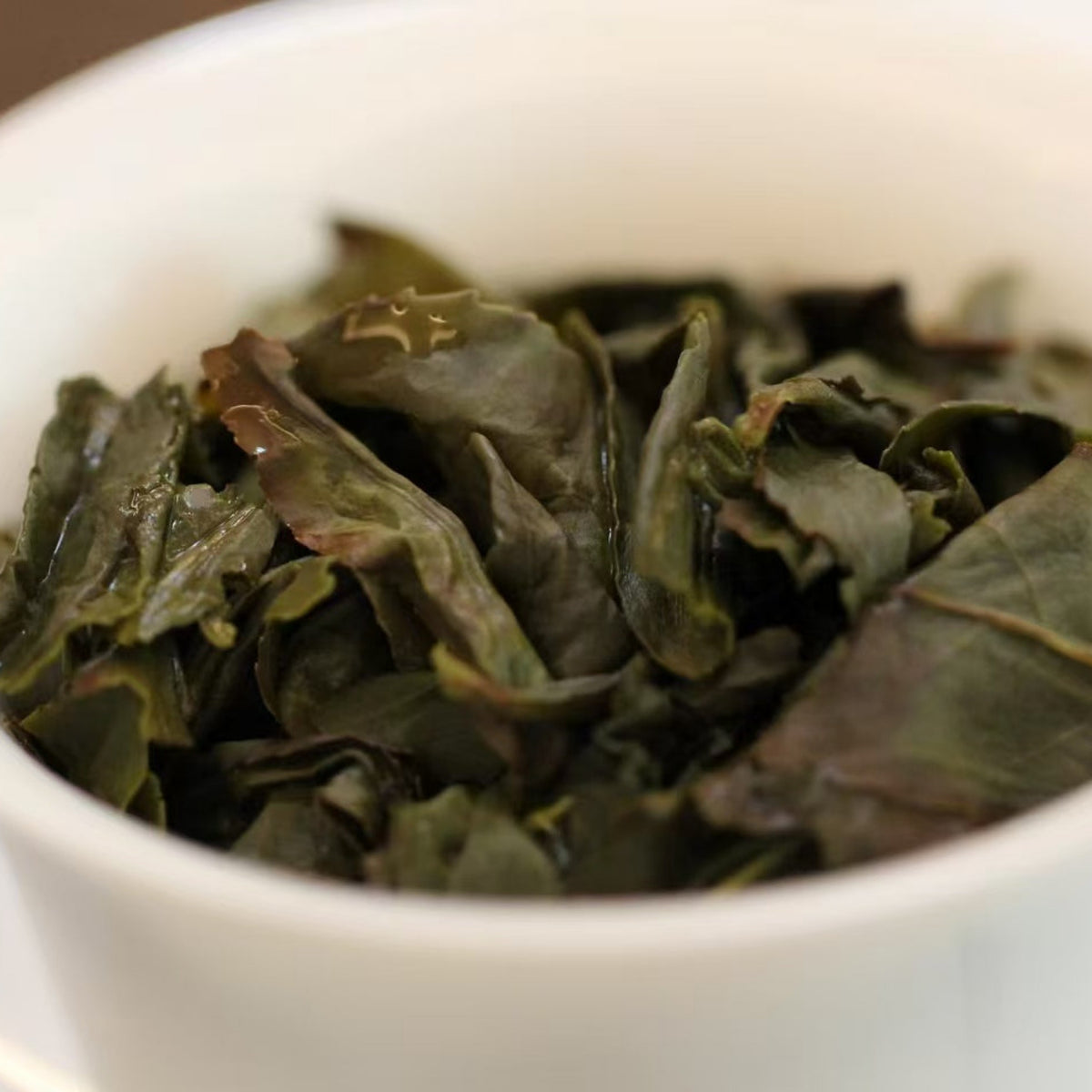 Yeyun Laocong Tieguanyin Oolong Tea wet leaf. Abandoned tea garden Tie Guan Yin tea in a white gaiwan.