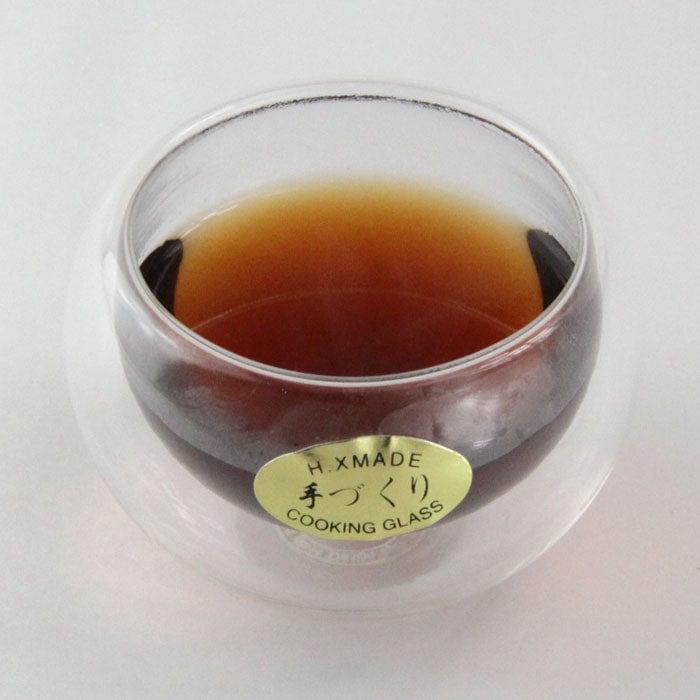 Double wall glass tea cup filled with a black tea
