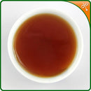 Bulang Shan Shu Puerh tea liquor in a Chinese tea cup.