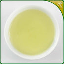 Premium Guanyin Wang tea liquor in a white ceramic, Chinese tea cup. 