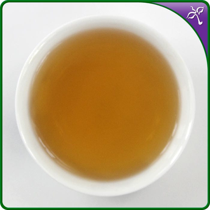 Close-up of Bai Ya Qi Lan Oolong Tea liquor in a white porcelain tea cup.