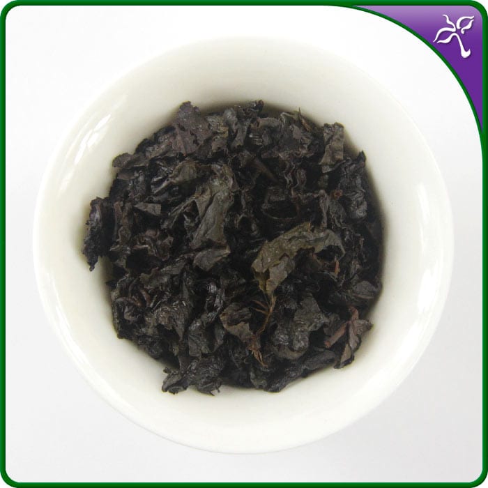 Close-up brewed Bai Ya Qi Lan Oolong Tea leaves in a white gaiwan.