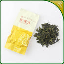 Tieguanyin oolong tea. One sealed 8g silver pouch of our Jiu Jiu Jiu Tieguanyin next to the loose leaf Tieguanyin tea.